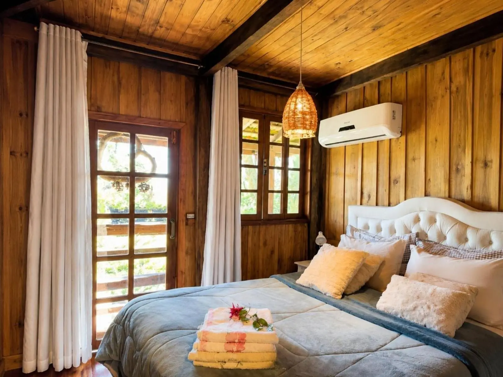 Segundo quarto, com cama queen e janelas