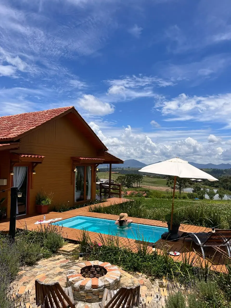 Gaia com a piscina, o guarda-sol e a serra ao fundo