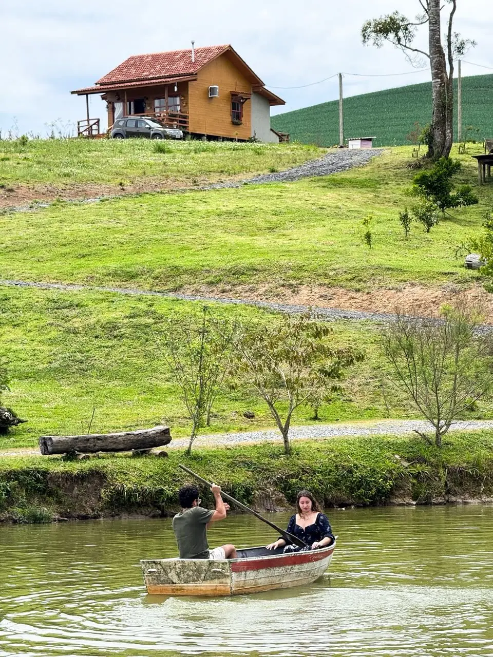 Gaia no alto do morro e o barquinho no lago lá embaixo